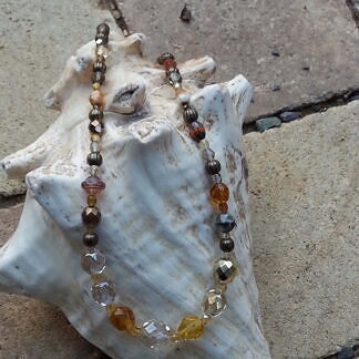 Kurze Halskette mit weissen, gelben, braunen und orangen Glasperlen, bronze Metallperlen und durchsichtigen, facettierten Glasperlen