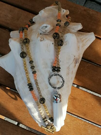 Lange Halskette Mala Perlenkette mit hellgelben orangen und khaki Katzenaugen weisser Quastenanhänger aus Lederimitat