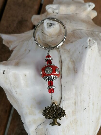 Schlüsselanhänger mit Lebensbaum mit roter Kashmiriperle mit weissen Strasssteinen roten kleinen Glasperlen Blumenrondellen und Anhänger in Bronze