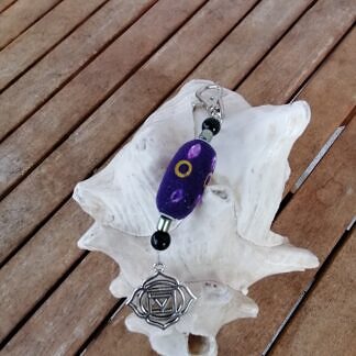 Yoga Schlüsselanhänger mit Kashmiriperle violett mit lila Strasssteinen schwarzen Acrylperlen lindgrünen Glanzperlen und Yoga Symbol Muladhara Chakra