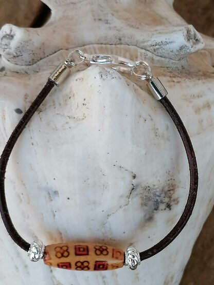 Kinder Armband mit dunkelbrauem Lederband ovaler indianischer Holzperle zwei Metallperlen und Karabinerverschluss