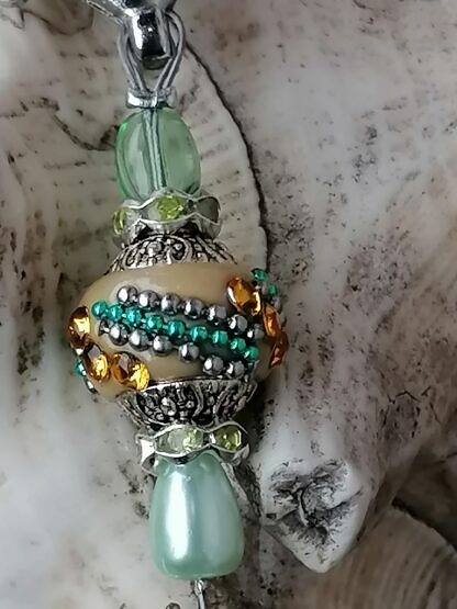 Schlüsselanhänger mit Einhorn mit lilaweissem Einhornanhänger grünen Glanz-und Glasperlen beiger Kashmiriperle mit gelben Strasssteinen und türkis Ornamenten