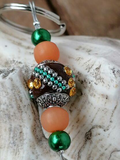 Schutzengel Schlüsselanhänger mit dunkelbrauner Kashmiriperle mit türkis und silbernen Ornamenten grünen Glanzperlen orange Polaris Glasperlen kleiner silberner Schutzengel