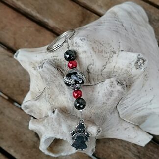 Schutzengel Schlüsselanhänger mit schwarzer Kashmiriperle mit weissen und silbernen Ornamenten roten Glanzperlen schwarzen Glasperlen kleinem silbernen Schutzengel