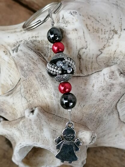 Schutzengel Schlüsselanhänger mit schwarzer Kashmiriperle mit weissen und silbernen Ornamenten roten Glanzperlen schwarzen Glasperlen kleinem silbernen Schutzengel