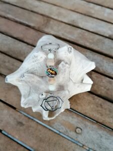 Yoga Schlüsselanhänger mit Kashmiri Perle dunkelbraun mit silbernen und türkis Ornamenten sowie orangen Strass hellen Holzperlen weissen Glasperlen und Yoga Symbol Ajna Stirn Chakra
