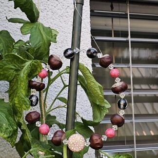 Drahtkranz Kastanienkranz Herbstdeko Fensterdeko Türdeko mit Kastanien schwarz glänzenden und durchsichtigen facettierten Acrylperlen pinke Fimoperlen runde rosa Acrylperlen mit Blumenmotiv