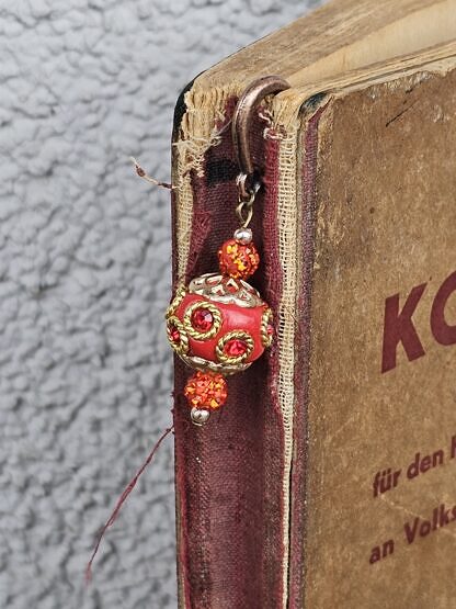 Lesezeichen Buchzeichen Antiksilber Bronze aus Metall mit handgemachter roter indonesischer Schmuckperle mit roten Strassteinen und goldenen Ornamenten und roten Shamballa Glitzerperlen