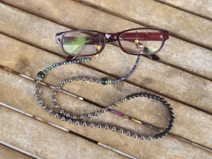 Brillenkette mit facettierten grünviolettgoldenen Glasperlen schwarzen und grauen Acrylperlen anthrazit Katzenaugenglasperlen schwarze Brillenschlaufe mit goldenen Karabiner