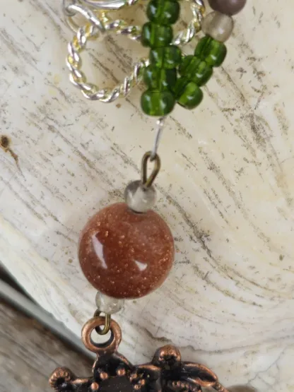 Lange Halskette mit kupferfarbenen Charm Metallanhänger Goldfluss Edelsteinperlen grünen grauen und dunkelbraunen Glasperlen Hakenverschluss Silber Halskette Gliederkette mit Anhänger