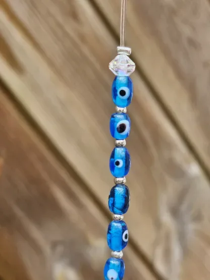 Schwemmholz Girlande Dekohänger Traumfänger Sonnenfänger mit dunkelblauen Pompons blauen Glasperlen Auge Fatimas diverse Formen von blauen Lampwork Perlen silberne Acryl Tibetperlen Perlkappen Metallperlen