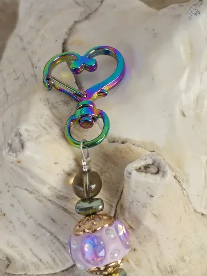 Schlüsselanhänger mit Einhorn mit weissem Anhänger mit gelb, blau und rosa Blumen Kashmiriperle in lila gold grüne Glanzperlen violette und hellbraune Glasperle