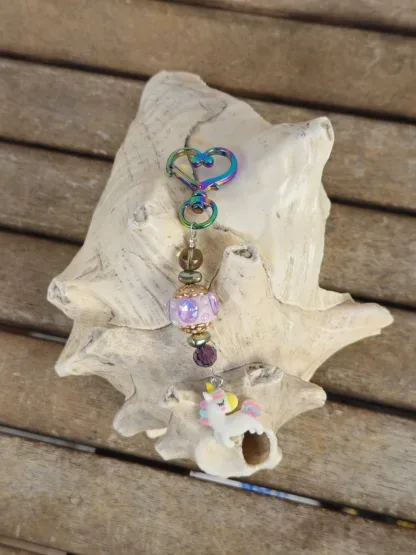 Schlüsselanhänger mit Einhorn mit weissem Anhänger mit gelb, blau und rosa Blumen Kashmiriperle in lila gold grüne Glanzperlen violette und hellbraune Glasperle