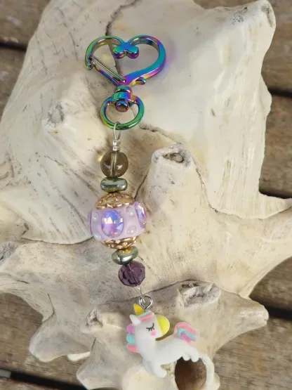 Schlüsselanhänger mit Einhorn mit weissem Anhänger mit gelb, blau und rosa Blumen Kashmiriperle in lila gold grüne Glanzperlen violette und hellbraune Glasperle