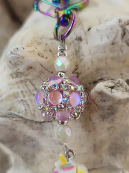 Schlüsselanhänger mit Einhorn mit weissem Anhänger mit gelb, blau und rosa Blumen Kashmiriperle in rosa facettierte weisse Glasperlen silberne Metallperlen