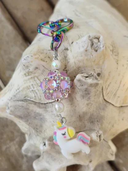 Schlüsselanhänger mit Einhorn mit weissem Anhänger mit gelb, blau und rosa Blumen Kashmiriperle in rosa facettierte weisse Glasperlen silberne Metallperlen