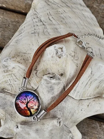 Lederarmband mit Cabochonperle Armkette Armband mit hellbraunen Lederbändern 20mm Cabochon Glasperle mit schwarzem Lebensbaum auf Abendstimmung Hintergrund rot gelb violett