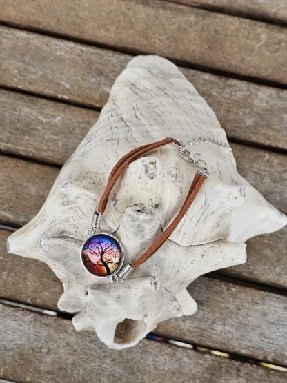 Lederarmband mit Cabochonperle Armkette Armband mit hellbraunen Lederbändern 20mm Cabochon Glasperle mit schwarzem Lebensbaum auf Abendstimmung Hintergrund rot gelb violett